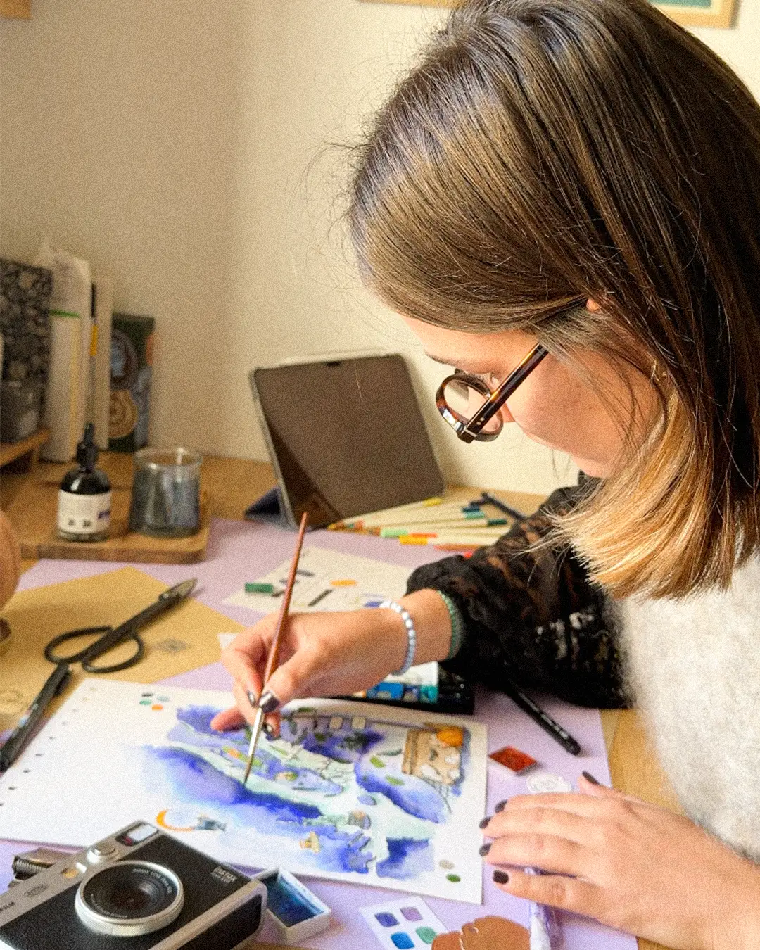 Manon Aubin peignant à l'aquarelle la carte de New York dans son atelier